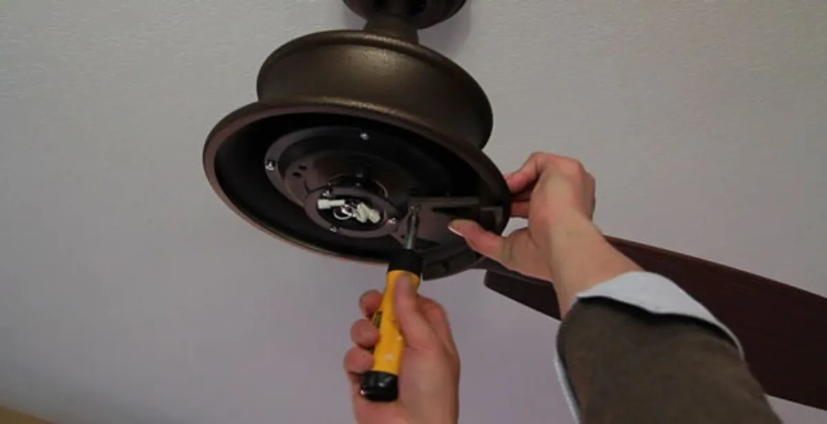 Electrician installing ceiling fan mounting bracket and fixture in Cleveland, OH