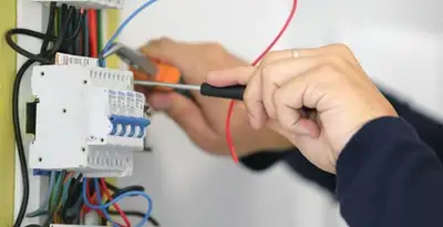 Electrician installing and adjusting circuit breakers in an electrical panel in Cleveland, OH