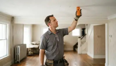 Cleveland, OH electrician using a stud finder to mark ceiling locations for lighting installation