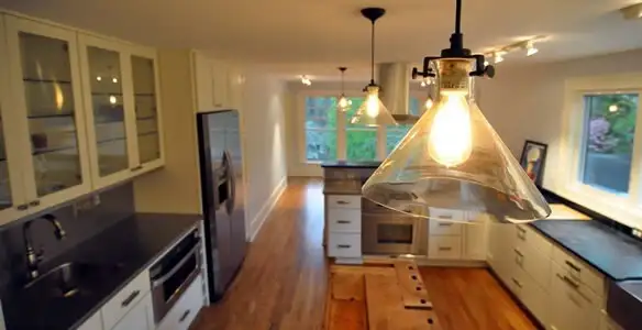 Residential electrician installing modern indoor light fixture in a home in Cleveland, OH