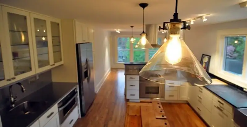 Residential electrician installing modern indoor light fixture in a home in Cleveland, OH